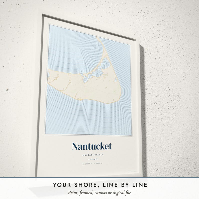 Three-quarter view of the framed Coastal Contour Map poster on a white plaster wall