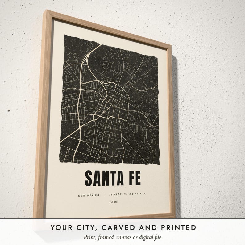 Three-quarter view of the framed Linocut City Map poster on a white plaster wall