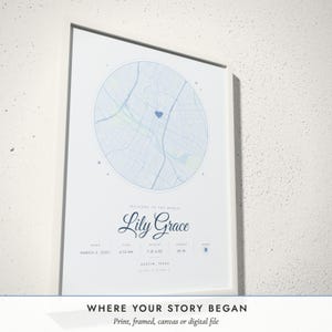 Three-quarter view of the framed Birth Map poster on a white plaster wall