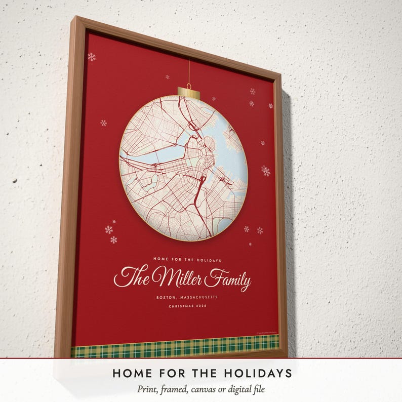 Three-quarter view of the framed Christmas Hometown Map poster on a white plaster wall