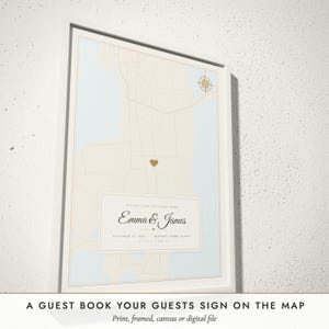 Three-quarter view of the framed Guest Book Map poster on a white plaster wall
