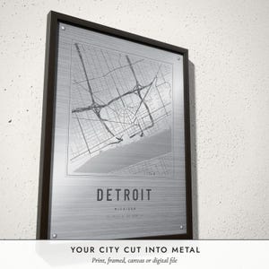 Three-quarter view of the framed Etched Metal City Map poster on a white plaster wall