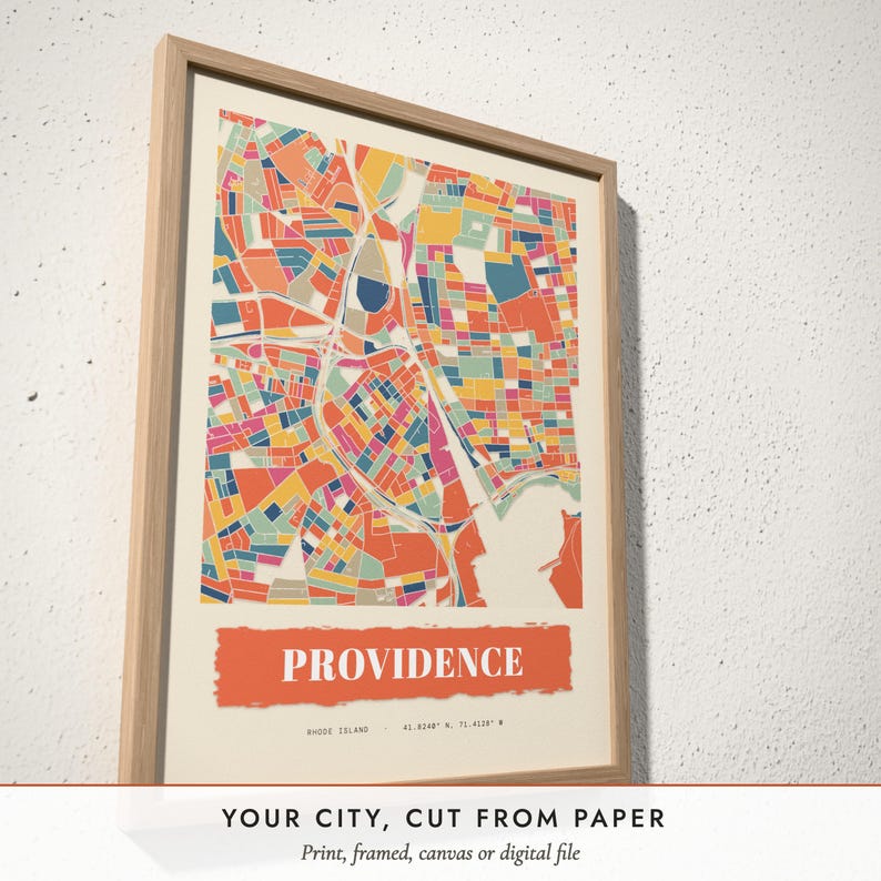 Three-quarter view of the framed Paper Collage City Map poster on a white plaster wall