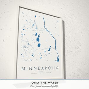 Three-quarter view of the framed Water Lines Map poster on a white plaster wall