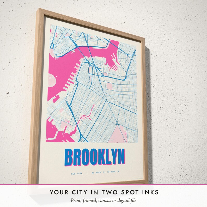 Three-quarter view of the framed Risograph City Map poster on a white plaster wall