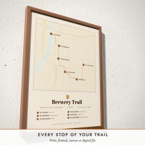 Three-quarter view of the framed Brewery Trail Map poster on a white plaster wall