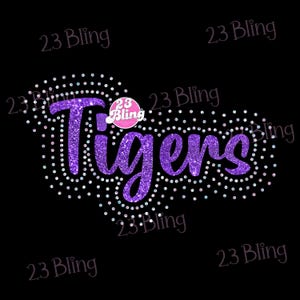 May include: A purple glitter design that says "Tigers" with a dotted outline of small, iridescent circles. The text is on a black background, with the words "23 Bling" in the corners.