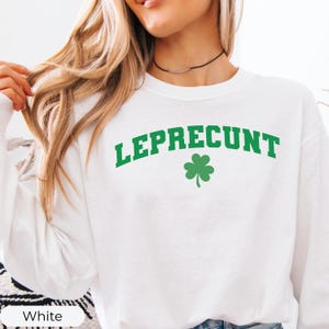 May include: White sweatshirt with the word "LEPRECONT" in green arched text above a green shamrock. The sweatshirt is a crew neck style.