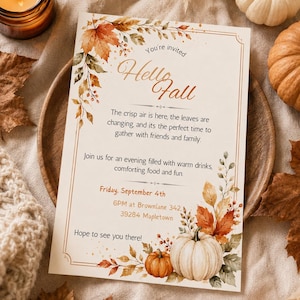 Op de afbeelding: Een rechthoekige uitnodigingskaart met herfstbladeren en pompoenen in aquarel. De tekst luidt: You're invited Hello Fall, The crisp air is here, the leaves are changing, and its the perfect time to gather with friends and family. Friday, September 4th, 6PM at Brownlane 342, 39284 Mapletown, Hope to see you there!