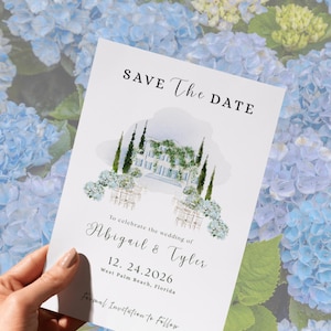 May include: A white wedding invitation with the text "SAVE The DATE" in elegant script. The invitation features a watercolor illustration of a building with floral accents. The names "Abigail & Tyler" and the date 12.24.2026 are also displayed.