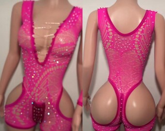 May include: A vibrant pink open-weave bodysuit with a plunging neckline and rhinestone detailing. The garment has a lace-up front and cut-out shorts. The back of the bodysuit is also open-weave with rhinestone accents.