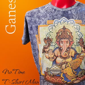 Puede incluir: Una camiseta azul y gris con una colorida ilustración de la deidad hindú Ganesha. El diseño es detallado y se encuentra sobre un fondo texturizado. La palabra "Ganesh" está impresa verticalmente a la izquierda. Parte de la "Collection: Ganesh".