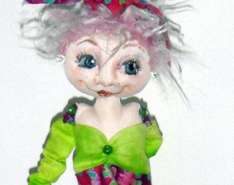 May include: A handmade doll with white hair, a pink and green polka dot dress, and a pink and green polka dot bow. The doll has blue eyes and a painted smile.