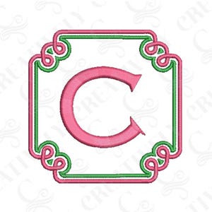 May include: Embroidered monogram letter C in pink with a green and pink square frame. The frame has a decorative knot design at each corner.