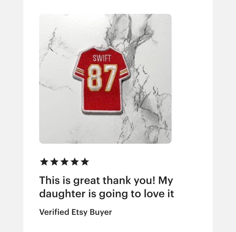 May include: A red and gold jersey patch with the name "SWIFT" and the number "87" on a white background. The patch is in the shape of a football jersey. The text "This is great thank you! My daughter is going to love it" is below the patch.