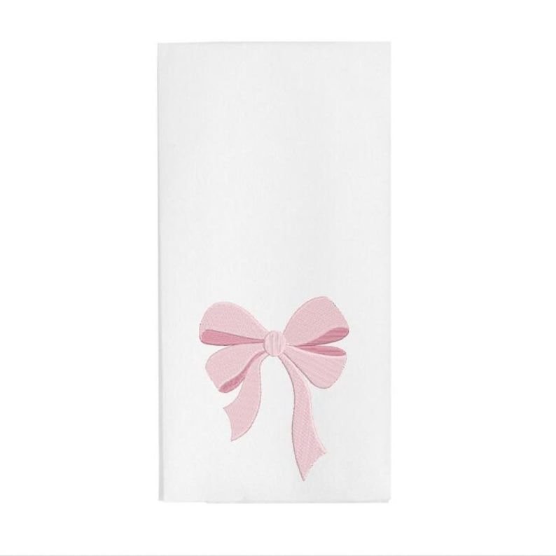 Peut inclure: Une serviette en tissu blanc rectangulaire orn&eacute;e d'un n&oelig;ud rose clair brod&eacute; au centre. Le motif du n&oelig;ud pr&eacute;sente des lignes cousues d&eacute;taill&eacute;es qui cr&eacute;ent une impression de profondeur et de texture, plac&eacute; vers la moiti&eacute; inf&eacute;rieure du tissu blanc.