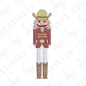 May include: Embroidered design of a cowboy nutcracker with a red jacket, white pants, and brown boots. The nutcracker is wearing a brown cowboy hat with a gold band.