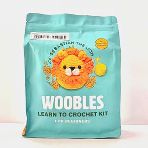 May include: A teal package featuring a crochet lion named Sebastian. The package reads "Woobles Learn to Crochet Kit for Beginners." A yellow circle indicates "All materials included."