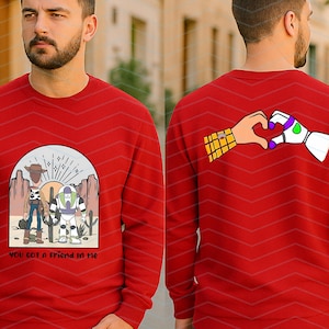 Pu&ograve; includere: Felpa rossa con una grafica di Woody e Buzz Lightyear in una scena desertica e la scritta "YOU GOT A FRIEND IN ME". Il retro mostra un cuore fatto con le mani di Woody e Buzz. Un design divertente e colorato.