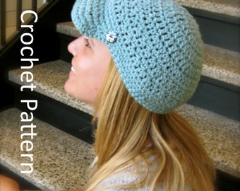 May include: A light blue crocheted beanie with a button detail. The beanie is worn by a person with long blonde hair.