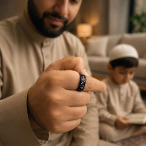 May include: A black digital ring featuring a small screen displaying the white numerical text 23:35. The band has a smooth, matte finish and is worn on a finger. The device is a wearable electronic accessory designed to show the current time clearly.