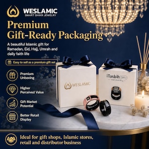 May include: Two smart dhikr rings, one rose gold and one black, displayed in front of two white gift boxes with navy blue ribbons. The boxes feature the Weslamic logo and the text iTasbih Peace 1 Smart Dhikr Ring. The rings have digital displays.