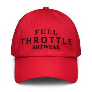 Puede incluir: Gorra de béisbol roja brillante con el texto negro "FULL THROTTLE ARTWEAR" en la parte delantera. La gorra tiene una visera curva y un cierre ajustable.