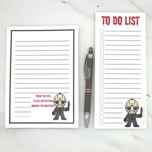 May include: Two white notepads with black lined pages and a brown pen. One notepad says "FRIDAY THE 13TH IS STILL BETTER THAN MONDAY, THE WHATEVER!" with a cartoon Jason Voorhees. The other notepad says "TO DO LIST" with a cartoon Jason Voorhees.