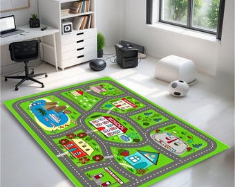 May include: A green and gray play rug with a road and town design. The rug features a school, houses, a lake with a boat, and a park with a Ferris wheel. The rug is designed for children's play and is placed on a white floor.