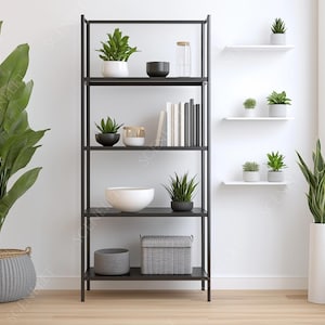 Puede incluir: Escena interior moderna con una estantería de metal negro llena de plantas, libros y objetos decorativos. A la izquierda, una gran planta en maceta con hojas verdes anchas, y a la derecha, un jarrón blanco alto con una planta.