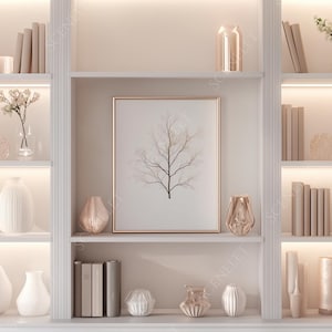 Puede incluir: Una estantería blanca empotrada con objetos decorativos. Los estantes exhiben jarrones blancos, libros y obras de arte enmarcadas. Arreglos florales y velas contribuyen a la estética. La paleta de colores es neutra con iluminación cálida.