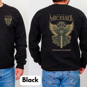 May include: Black sweatshirt featuring a gold and teal graphic of a sword and wings, with the text "SAINT MICHAEL" and "Defend us in Battle". The front of the sweatshirt has a smaller matching graphic and the word "MICHAEL".