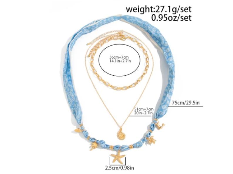 Op de afbeelding: Een gelaagde ketting set met een blauwe stoffen band en goudkleurige kettingen. De set bevat een zeester hanger (2,5cm), een schelp hanger en een ketting van 51cm+7cm lang. De stoffen band is 75cm lang. Het setje weegt 27,1g.