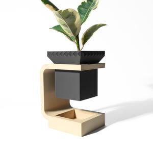 May include: A modern plant stand with a black square planter featuring a textured rim, holding a plant with green and cream-colored leaves. The planter sits on a light wood-colored shelf, supported by a curved, light wood-colored frame.