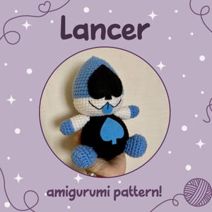 Puede incluir: Muñeco Lancer de ganchillo con un diseño de pica azul y negro. El muñeco tiene una cabeza azul y blanca, un cuerpo negro y extremidades azules. La palabra "Lancer" está encima del muñeco, y "amigurumi pattern!" debajo.