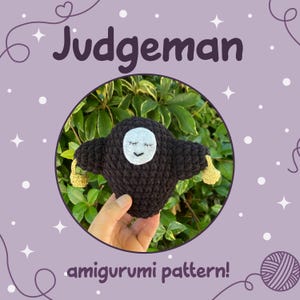Puede incluir: Muñeca amigurumi negra hecha a mano con una cara blanca y ojos cerrados, sosteniendo pequeños apéndices amarillos. La muñeca está colocada sobre un fondo verde dentro de un marco circular, con la palabra "Judgeman" arriba y "amigurumi pattern!" abajo.