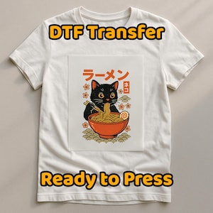 May include: White t-shirt with a DTF Transfer design. The design shows a black cat eating ramen from an orange bowl, with Japanese text and floral accents. The words "DTF Transfer" and "Ready to Press" are printed on the shirt.