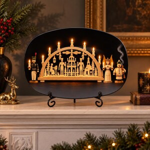 May include: An oval black display stand holds a light-colored wooden candle arch featuring intricate cutouts of figures, trees, and a building. Seven electric candles illuminate the arch, flanked by a soldier, an angel, and a snowman figurine.