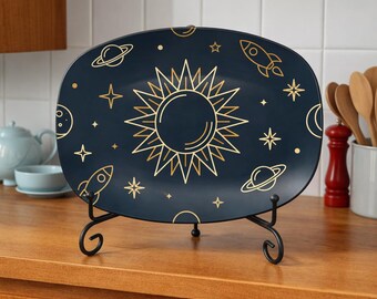 May include: A navy blue rectangular serving platter with a gold celestial design. The design includes a sun, stars, planets, and rockets. The platter is displayed on a black metal stand, perfect for serving appetizers or desserts.