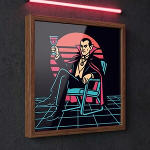 Puede incluir: Impresión artística enmarcada que representa a un vampiro sentado en una silla, sosteniendo una copa. La obra de arte tiene un estilo retro con un fondo de puesta de sol y un patrón de cuadrícula. El vampiro viste un traje negro y una capa.