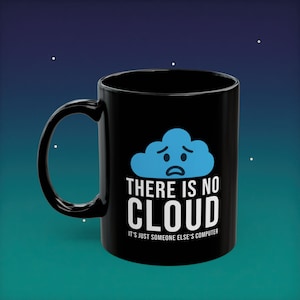 May include: Black ceramic coffee mug with a white handle. The mug features a blue cloud graphic with a sad face and the text "THERE IS NO CLOUD" and "IT'S JUST SOMEONE ELSE'S COMPUTER" in white. The mug is a standard 325 ml size.