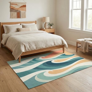 May include: A bedroom scene featuring a wooden bed with beige bedding and a colorful rug. The rug has a wave design in shades of blue, teal, orange, and cream. A woven wall hanging and a small side table with a lamp complete the room's decor.
