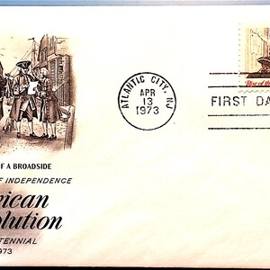 May include: A first day of issue envelope for the American Revolution Bicentennial 1973 stamp. The envelope features a black and white illustration of people reading a broadside. The stamp depicts a group of people ringing a bell. The envelope is postmarked "Atlantic City, NJ, Apr 13, 1973".