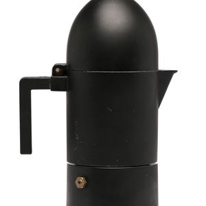 Puede incluir: Una cafetera italiana negra mate con una parte superior redondeada y un asa pequeña. La cafetera tiene un pico para verter y un pequeño pomo en la parte superior. La cafetera está hecha de metal.