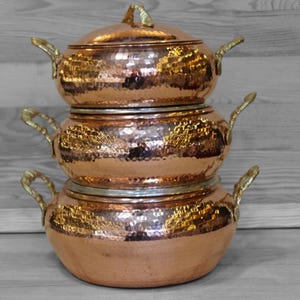 Peut inclure: Ensemble de trois mugs en céramique avec une finition mate et mouchetée. Les tasses sont de couleur crème, gris clair et gris foncé. Design simple et minimaliste.