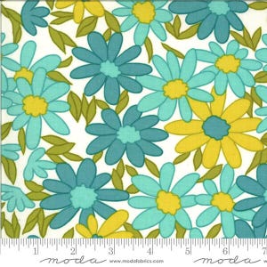 May include: A white fabric featuring a repeating floral pattern of daisies in shades of teal, light blue, and yellow with olive green leaves. A white measuring tape is visible at the bottom, showing a scale of 7 inches for reference.