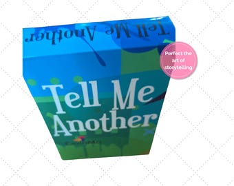 Könnte beinhalten: Eine blau-grüne Box mit dem Schriftzug "Tell Me Another" in Weiß. Die Box hat ein geometrisches Design und einen rosa Kreis mit der Aufschrift "Perfect the art of storytelling".