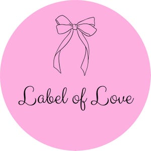 Peut inclure: Un cercle rose avec un dessin au trait noir d'un nœud en haut. Les mots "Label of Love" sont écrits en cursive en dessous du nœud.