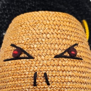 Detail of felt eyes and red wool embroidery on 1940s purse