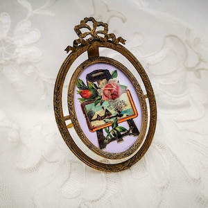 Antique french gilded metal, ormolù, oval photo frame, embossed design of leaves garlands & bow, movable, with Victorian era die cut chromo